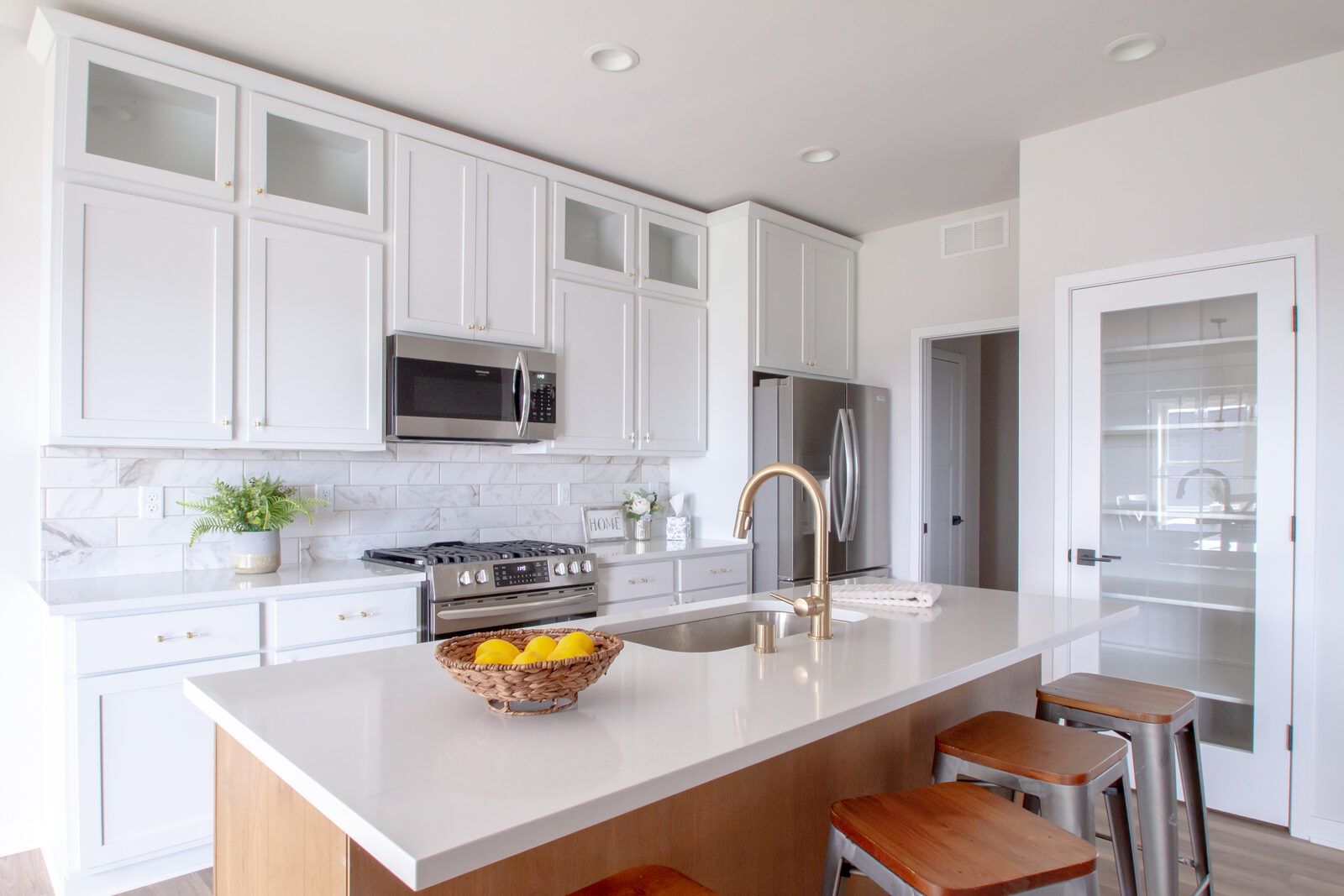 Kitchen remodel with white cabinetry and brass fixtures by Corinth