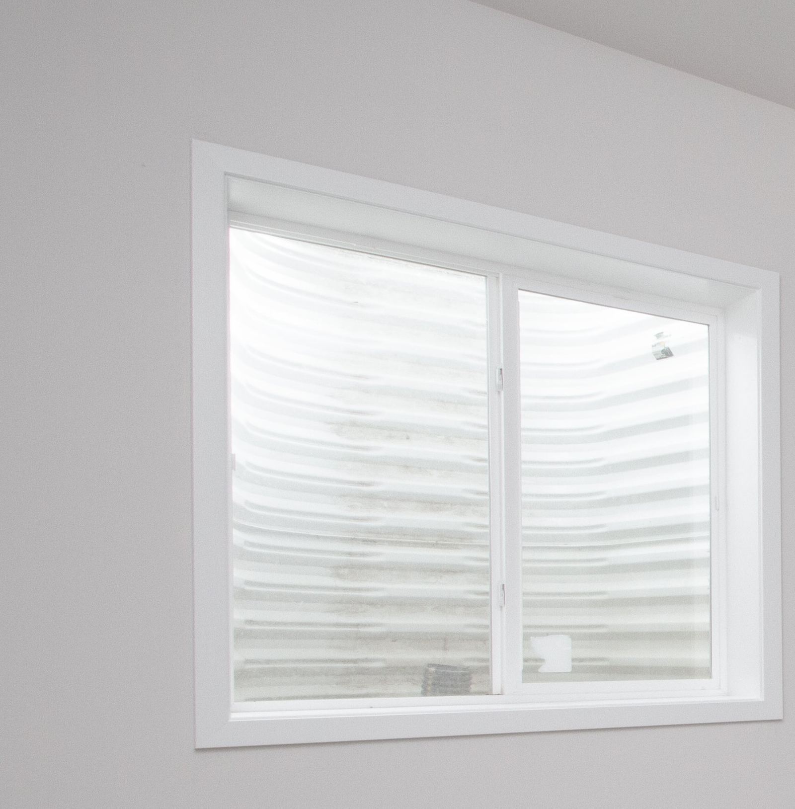 Finished basement bedroom with a code-compliant egress window installed by Corinth Basement Remodeling